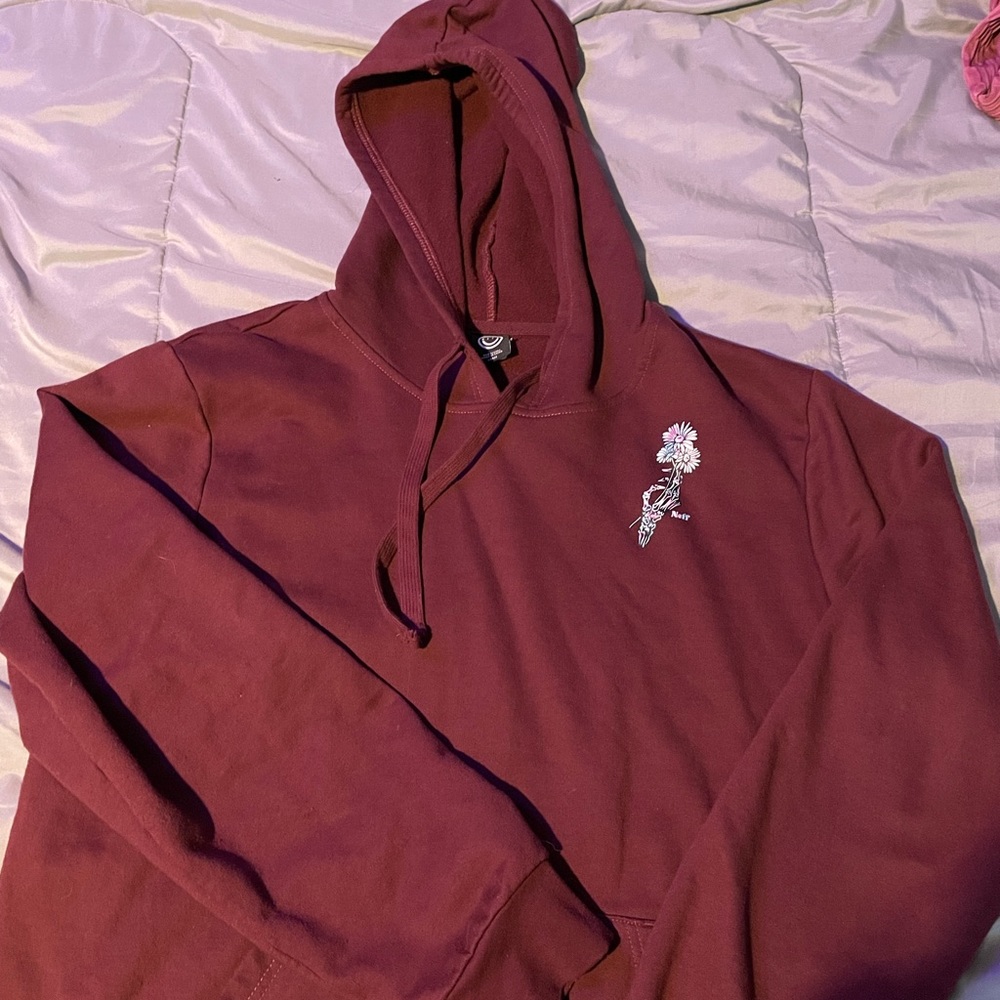 Skeleton hand holding daisies